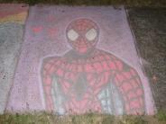 sidewalk chalk art black and red image of spiderman with black spider on the front of his uniform has purple background
