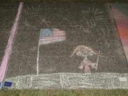 sidewalk chalk art picture of child holding a sparkler under an American flag